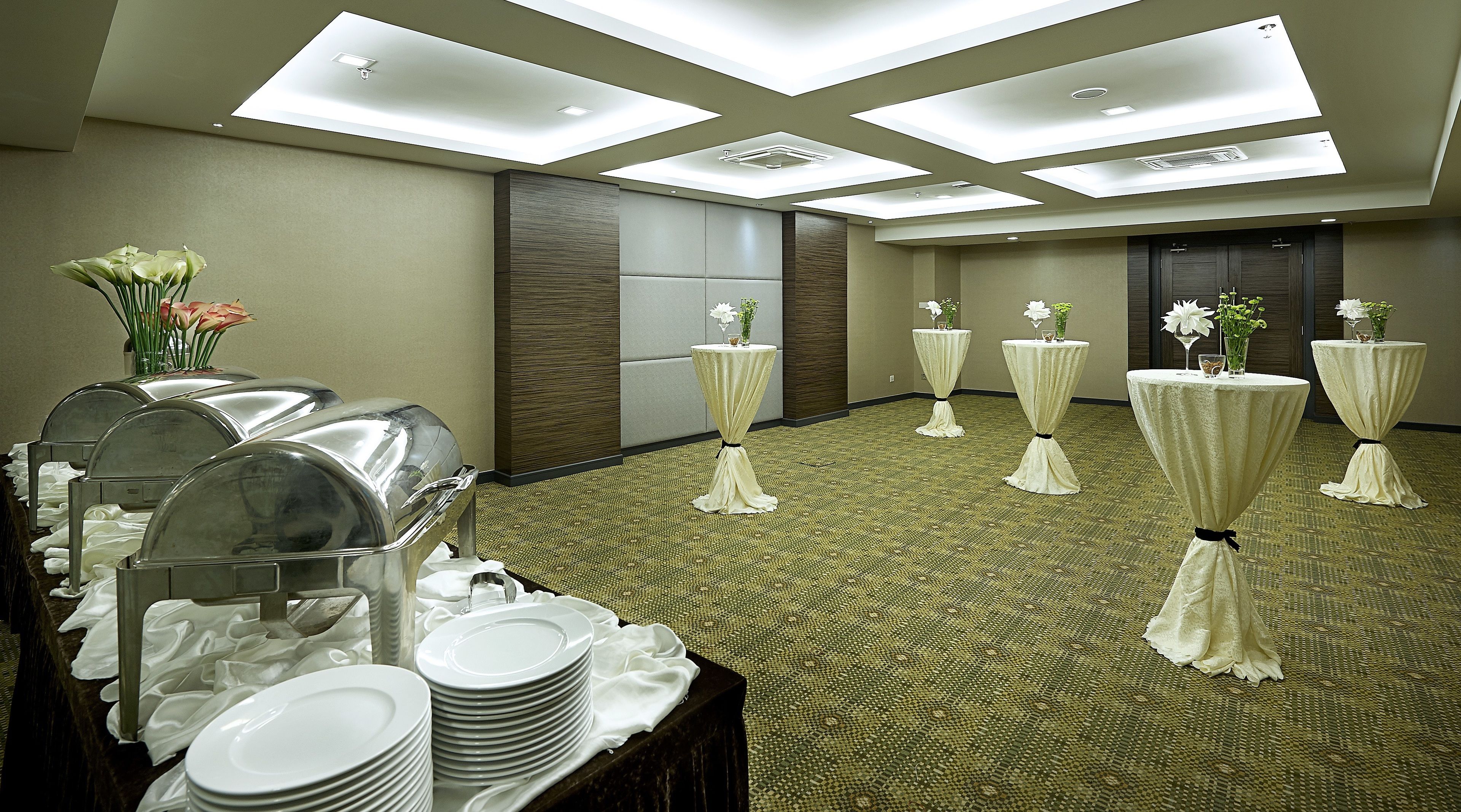 A conference room with tables set for a meeting, equipped with microphones and a projector.
