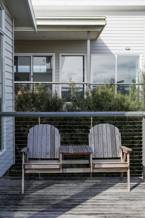 Relax on the balcony with Adirondack chairs and lush greenery.