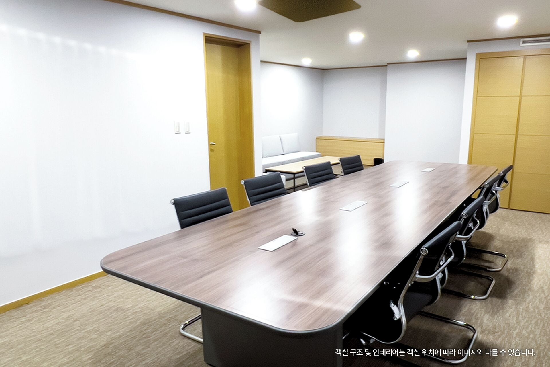 A conference room with a long table, chairs, and a sofa.