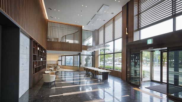 A spacious lobby with a high ceiling, a central seating area, and large windows offering views of the outdoors. - Hotel Interciti (Daejeon)