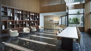 A modern lobby with a long reception desk, seating area, and shelves with vases. - Hotel Interciti (Daejeon)