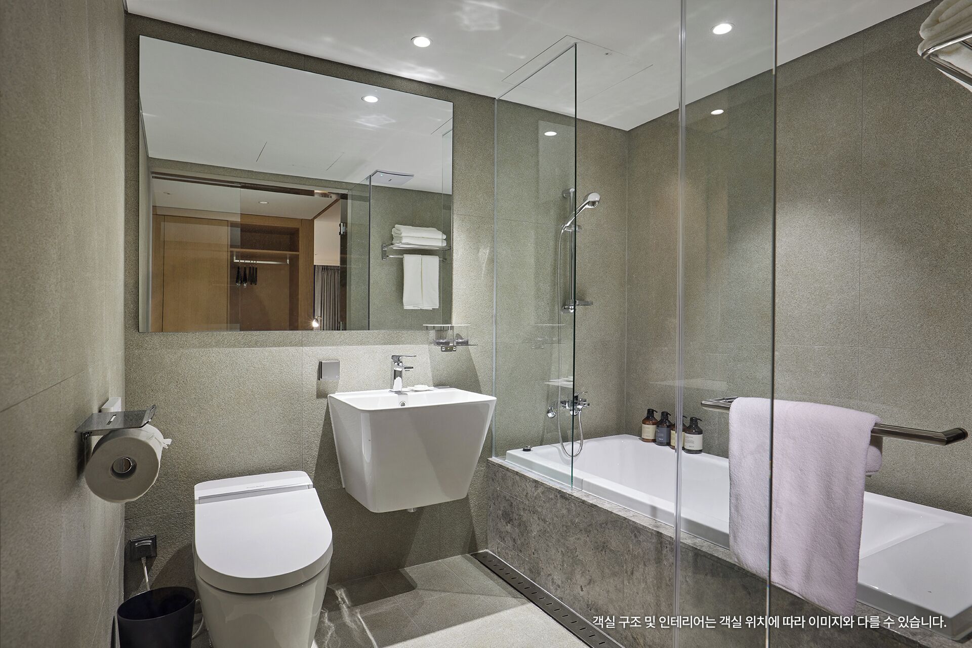 A modern bathroom with a toilet, sink, and bathtub.