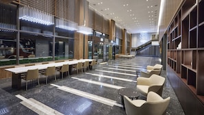 A spacious indoor area with a long table and chairs, a staircase, and a modern ceiling design. - Hotel Interciti (Daejeon)