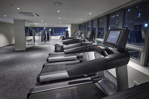 A gym with treadmills, exercise equipment, and large windows with city views. - Hotel Interciti (Daejeon)