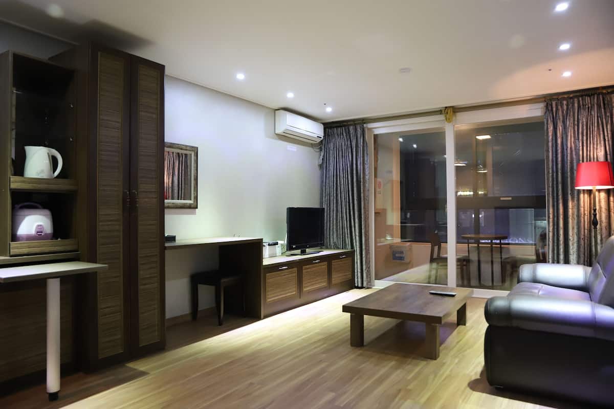 A modern living room with a sofa, a coffee table, a TV, and a desk.