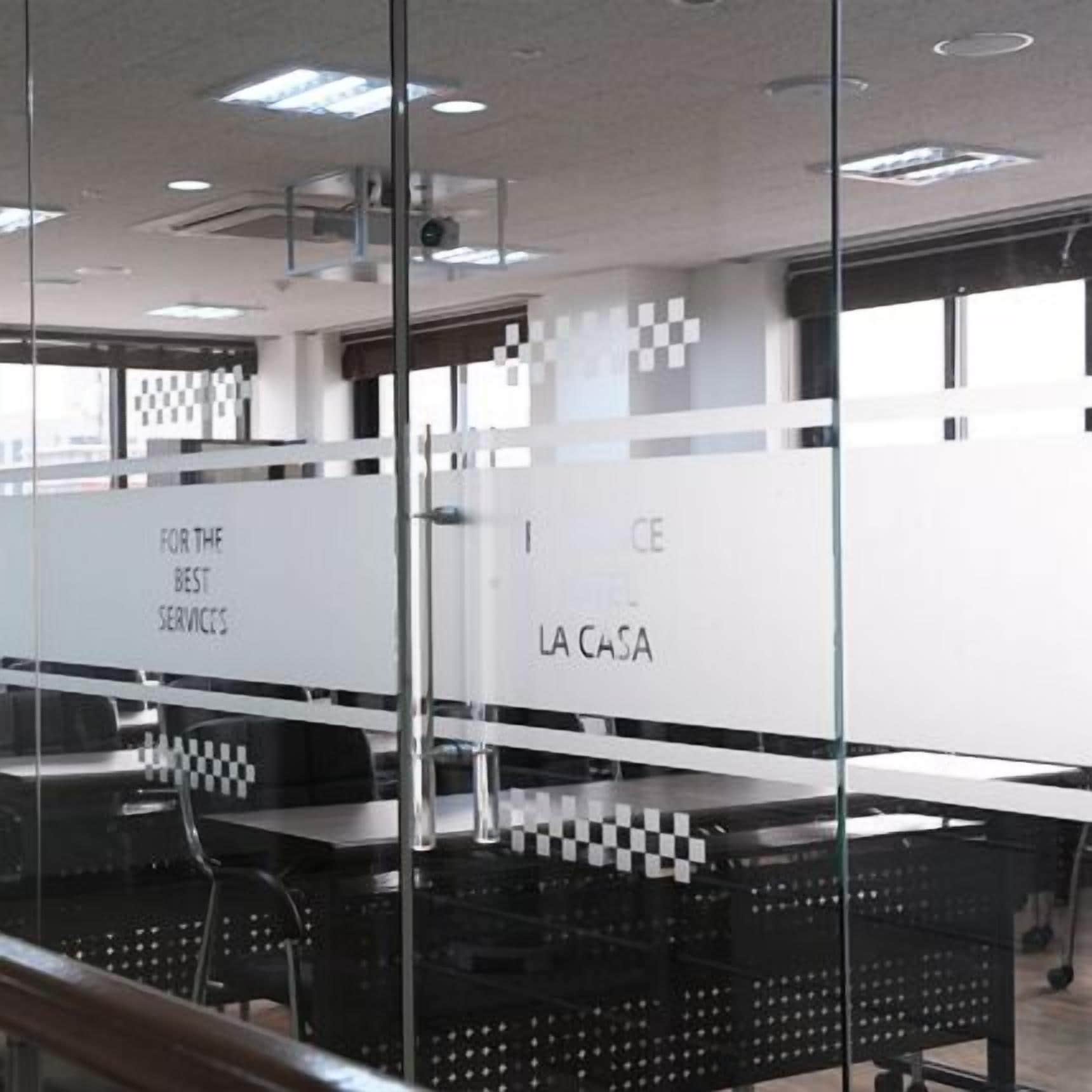 A modern office space with glass partitions, each labeled with different service areas like "FOR THE BEST SERVICES" and "LA CASA".