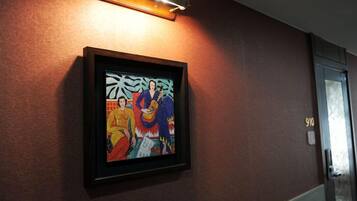 A framed artwork on a wall with a door labeled "910" to the right.