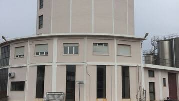 Ein mehrstöckiges Industriegebäude mit einer gebogenen Fassade, großen Fenstern und einem flachen Dach.