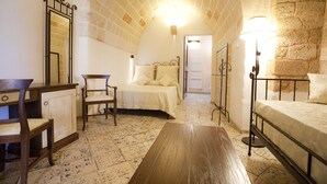 Un dormitorio con cama, una silla, un escritorio y una lámpara.