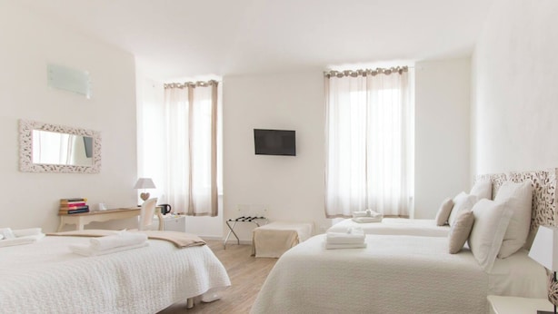 Een hotelkamer met twee bedden, een televisie, een bureau met lamp en een spiegel.