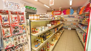 Un negozio con scaffali pieni di vasetti di condimenti, spezie e altri prodotti alimentari.