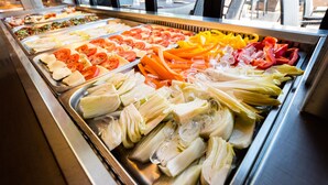 Un buffet con diverse verdure fresche e carni.