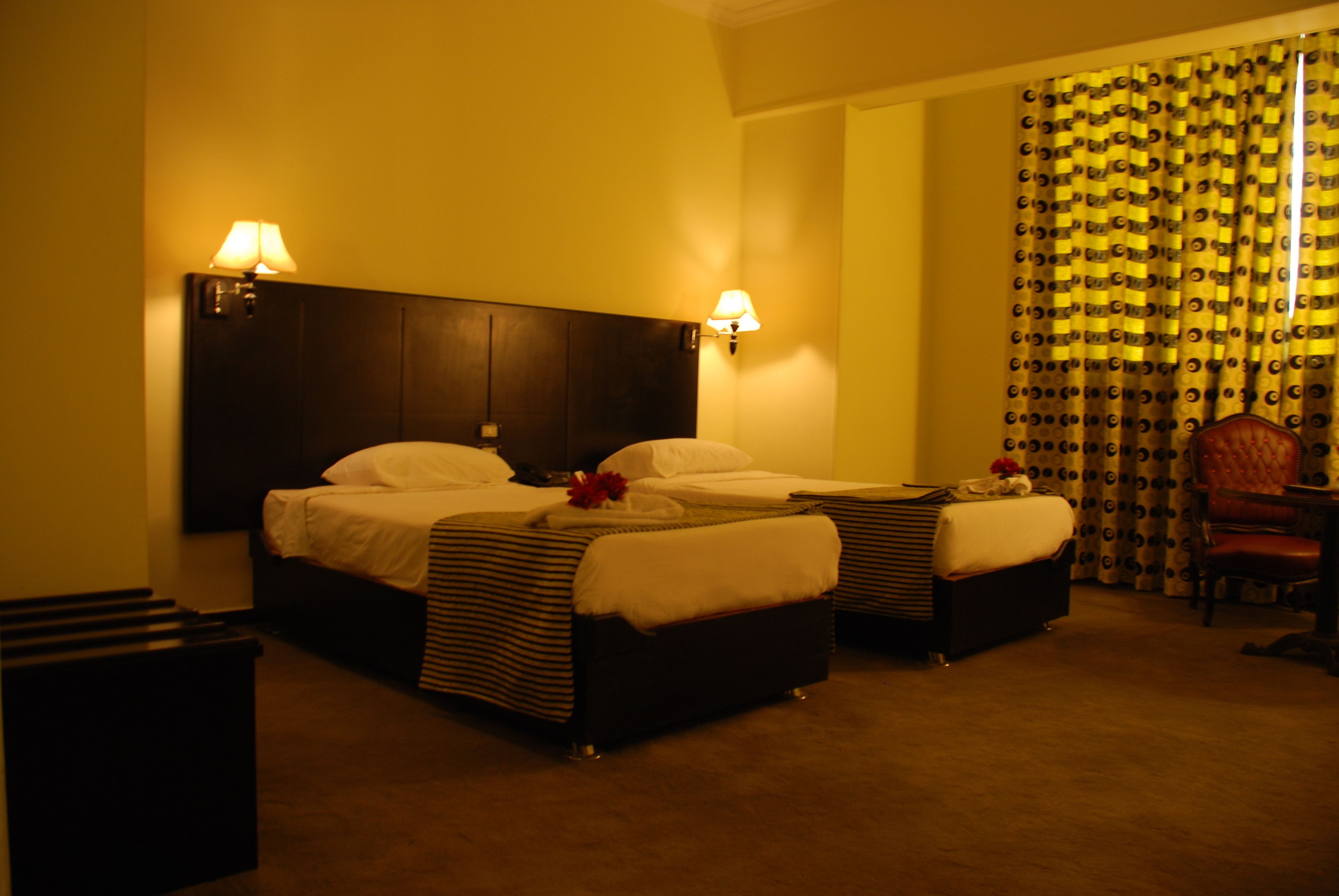 Una habitación de hotel con dos camas, una mesita y una silla.