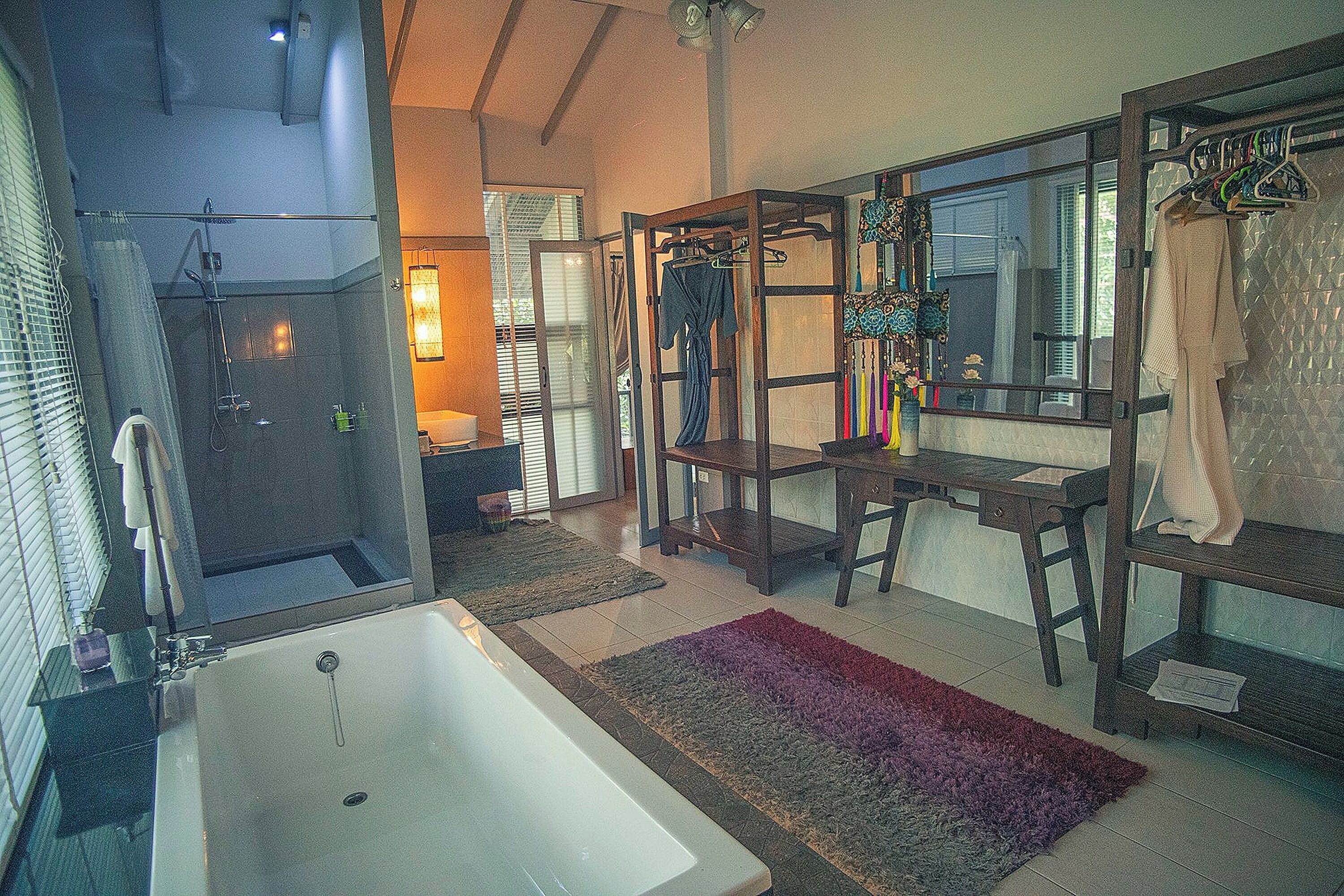 A modern bathroom with a bathtub, shower, and a vanity with a mirror.