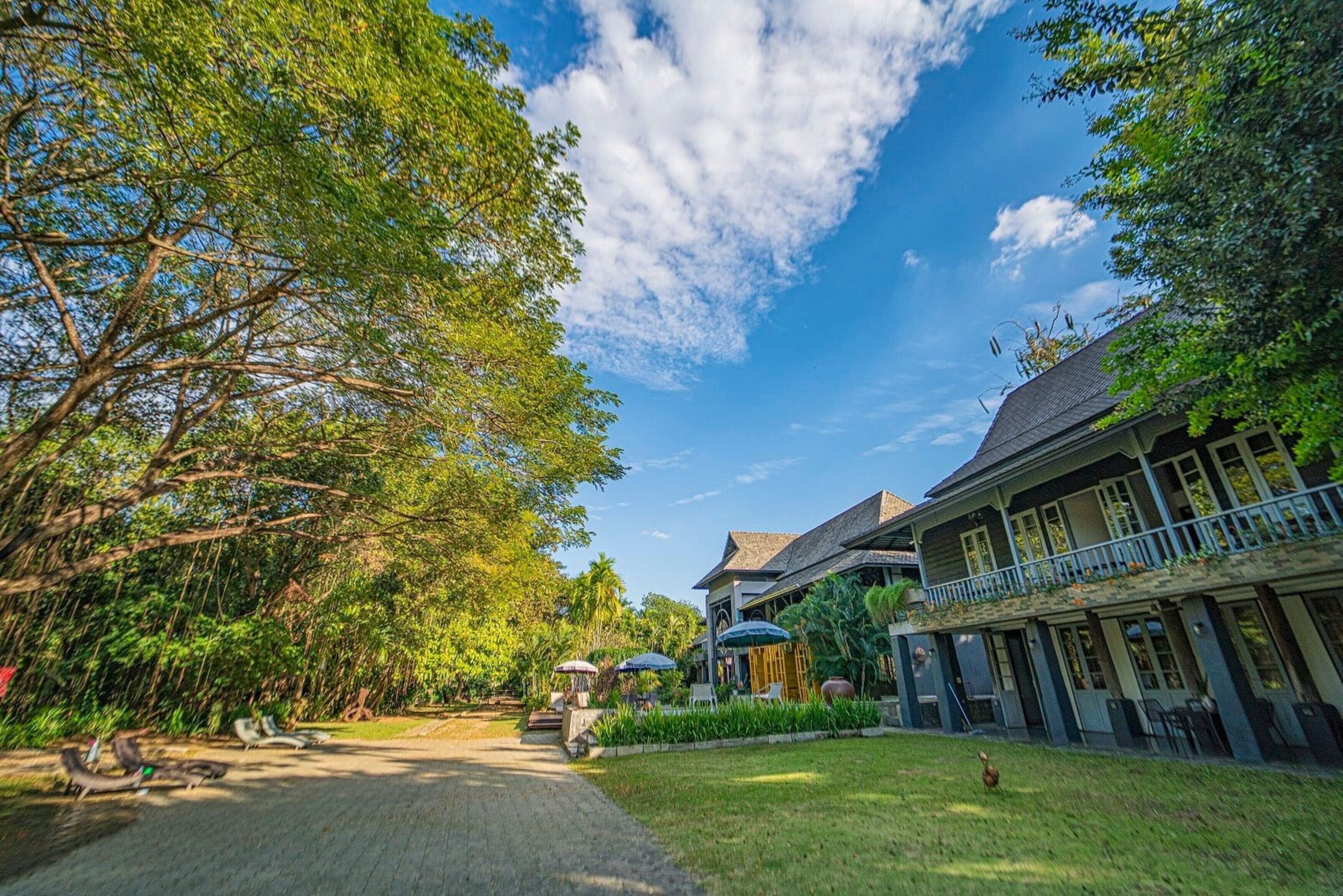 A traditional house with a garden, a pathway, and a clear sky.