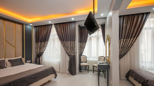 A modern hotel room with a large bed, a desk, and a sofa. - Hotel Next2 (Istanbul)