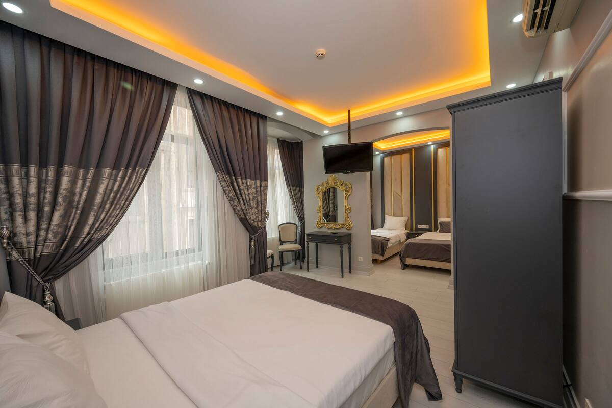 Una habitación de hotel con una cama grande, un escritorio, una silla, un armario y un televisor.