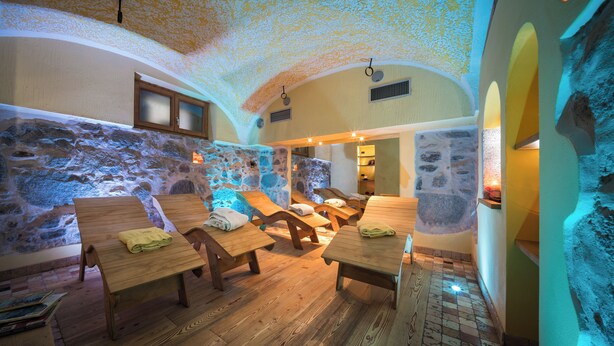 A spa room with wooden benches and stone walls. - Hotel Wanda (Pinzolo)