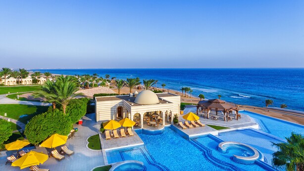 A resort with a large pool, sun loungers, umbrellas, and a view of the ocean. - The Oberoi, Sahl Hasheesh (Hurghada)