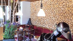 L’intérieur d’un restaurant avec des poutres en bois, un mur en pierre et une décoration sur le thème de la moto.