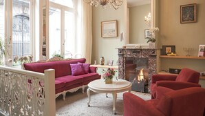 A living room with a red sofa, a white coffee table, and a fireplace.