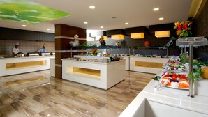 A modern hotel lobby with a reception desk, a buffet area, and a decorative ceiling. - Kleopatra Ramira Hotel - All Inclusive (Alanya)
