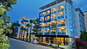 A multi-story hotel with balconies, a well-lit entrance, and a clear view of the street. - Kleopatra Ramira Hotel - All Inclusive (Alanya)