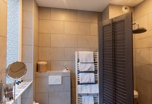 A modern bathroom with a shower, a towel rack, and a mirror. - Hotel de l'Avre (Paris)