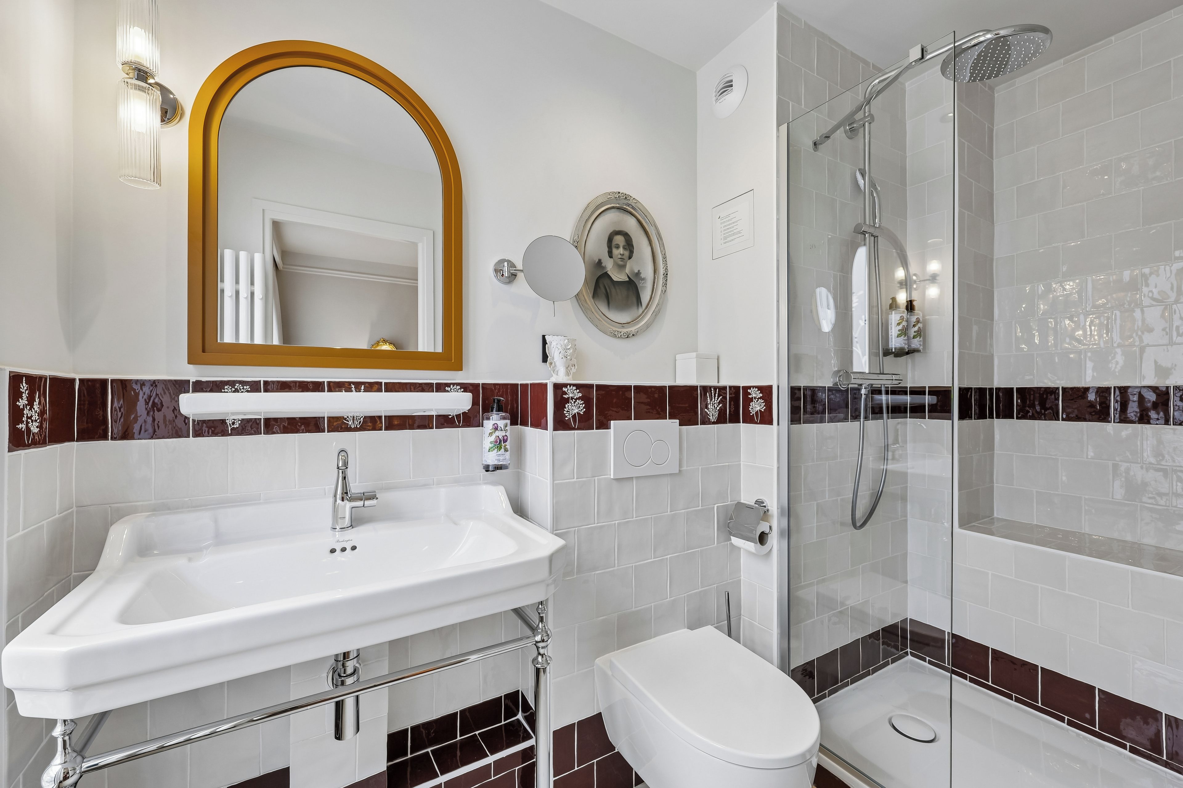 A bathroom with a white sink, a toilet, and a glass-enclosed shower.