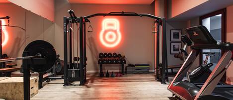 Une salle de sport équipée de matériel de musculation, de tapis de course et d’haltères.