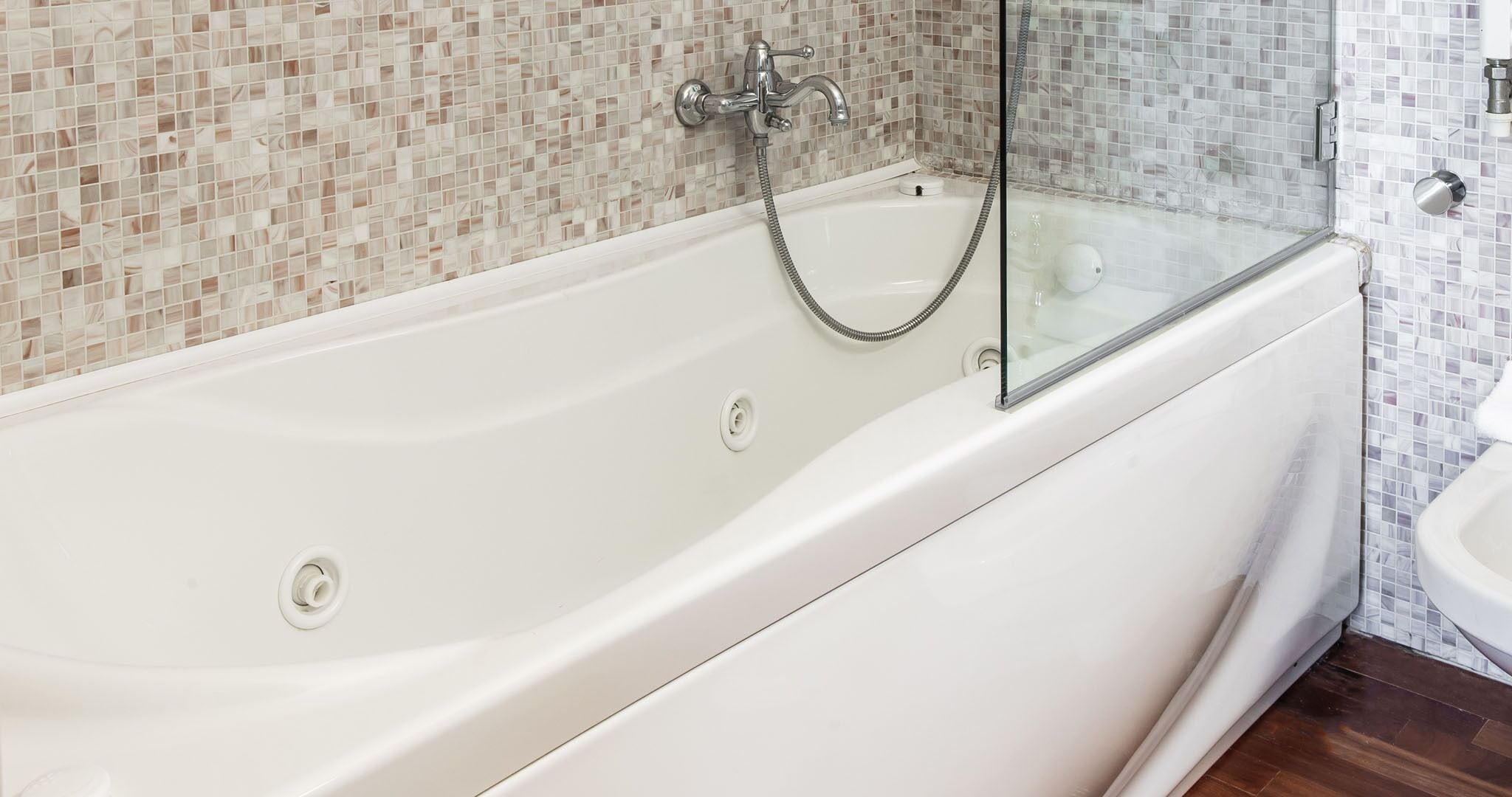 A modern bathroom with a freestanding bathtub, a glass-enclosed shower, and a white sink.
