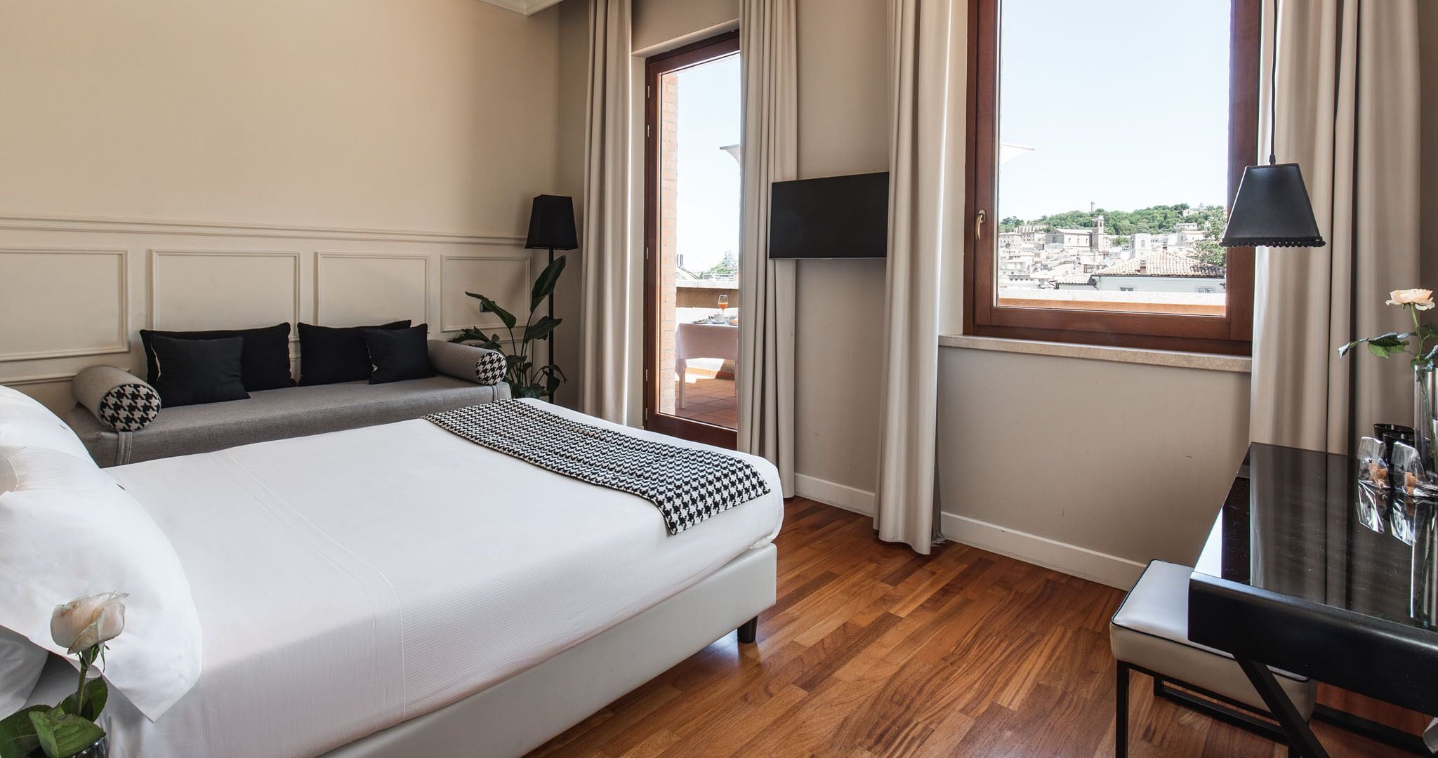 Habitación de hotel con una cama grande, un sofá, un escritorio y un televisor.
