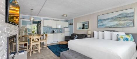 Et moderne hotelværelse med en stor seng, spiseplads og et køkken.
