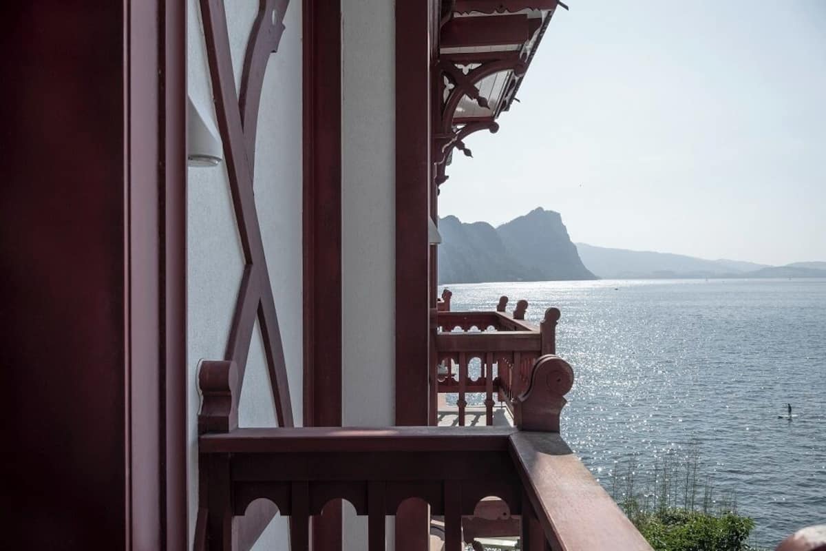 Un balcón con vista a un mar tranquilo y montañas lejanas.