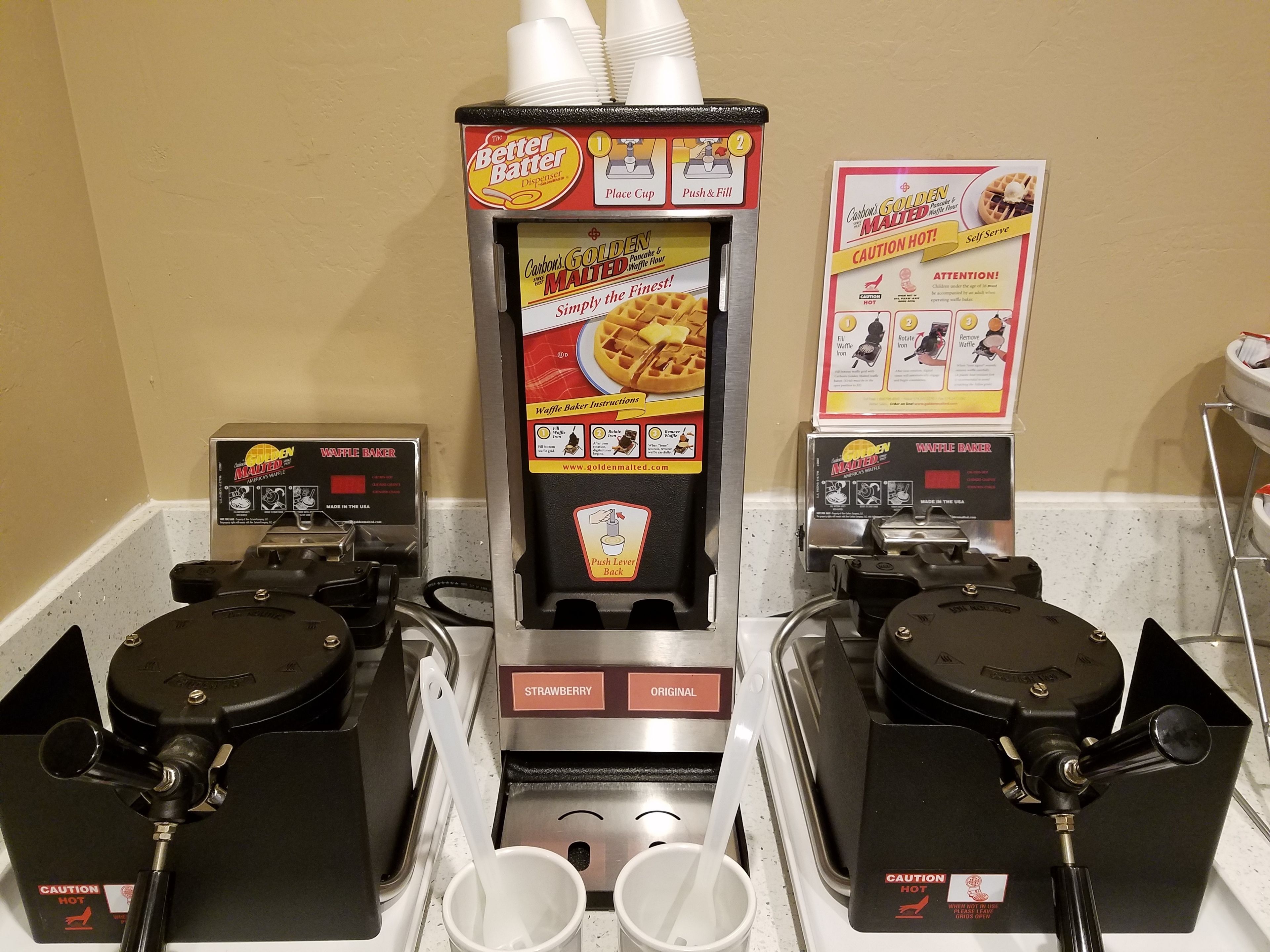 A waffle maker with instructions and a self-serve sign.