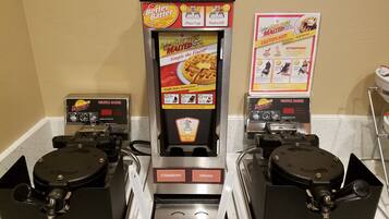 A waffle maker with instructions and a self-serve sign.