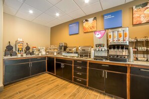 A breakfast bar with various food and drink options, including waffle makers, coffee machines, and a Nescafe display.