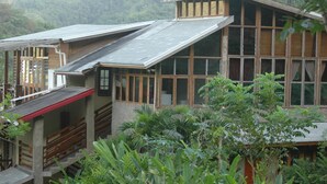 A modern house with a sloped roof, large windows, and a surrounding garden. - Forres Park Resort & Spa (Mavis Bank)