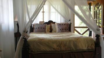 A bed with a canopy, a wooden headboard, and a window with curtains.