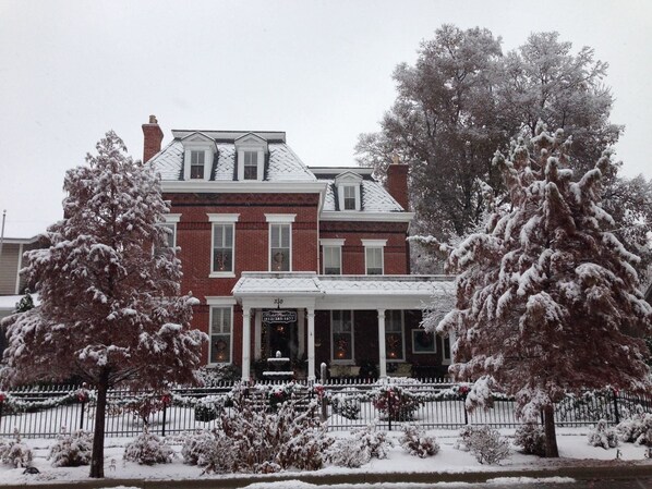 A two-story brick building with a white porch and a sign reading "Hotel".