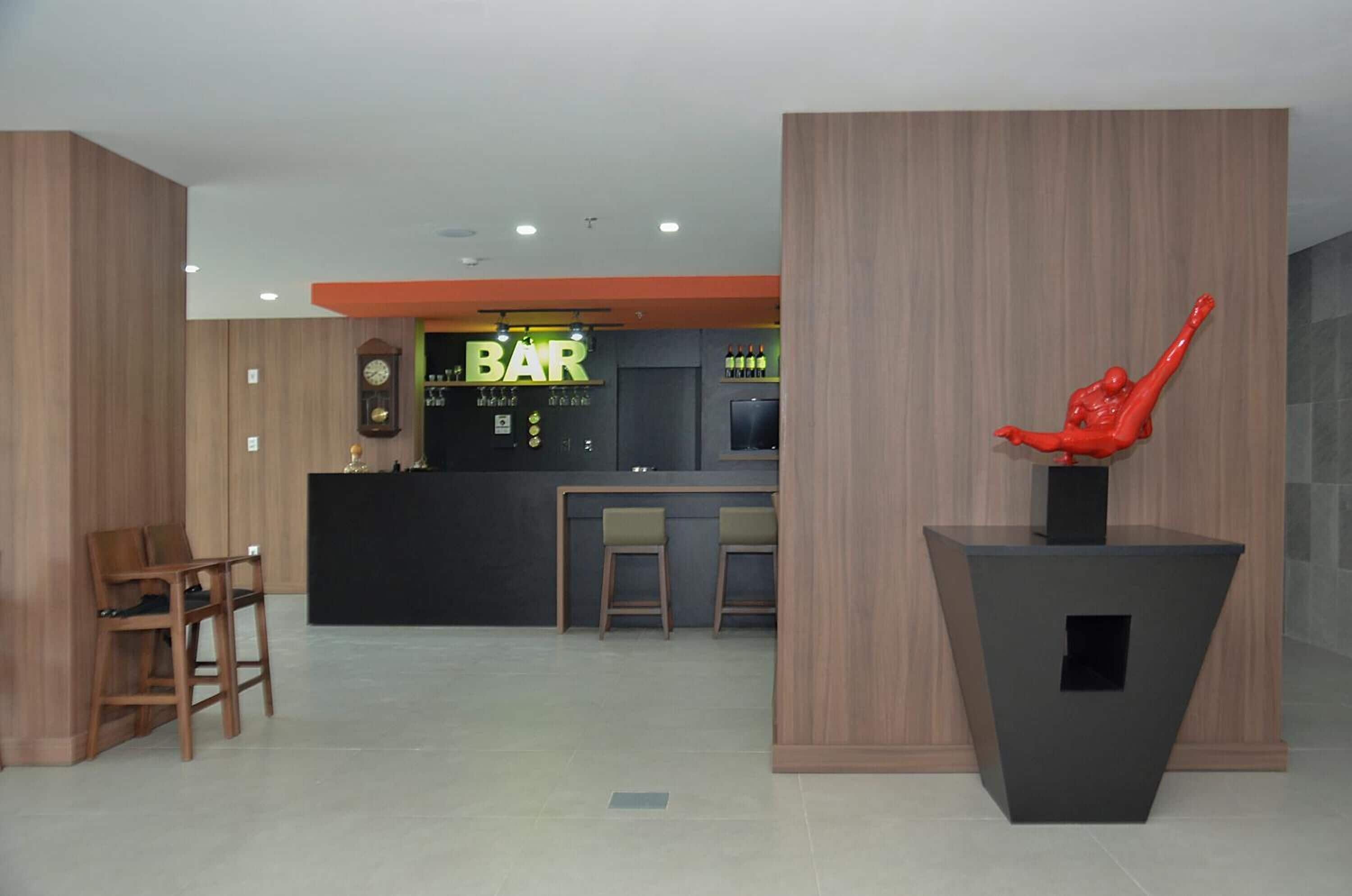 A bar area with a counter, stools, and a clock on the wall.