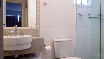 Een moderne badkamer met een wastafel, toilet en douchecabine met glazen wanden.