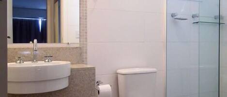 A modern bathroom with a sink, toilet, and glass shower enclosure.