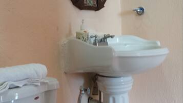 Un baño con inodoro, lavamanos y espejo.