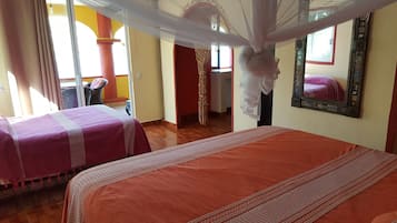 Hotellihuone, jossa on kaksi sänkyä, parveke ja suuri peili.