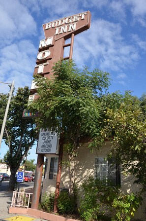 A motel sign with amenities including a low daily rate, color TV, phone, air conditioning, and kitchen. - Budget Inn (South Gate)