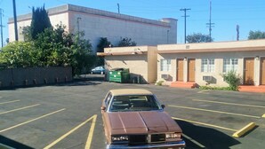 Un parking avec une voiture ancienne garée au premier plan.