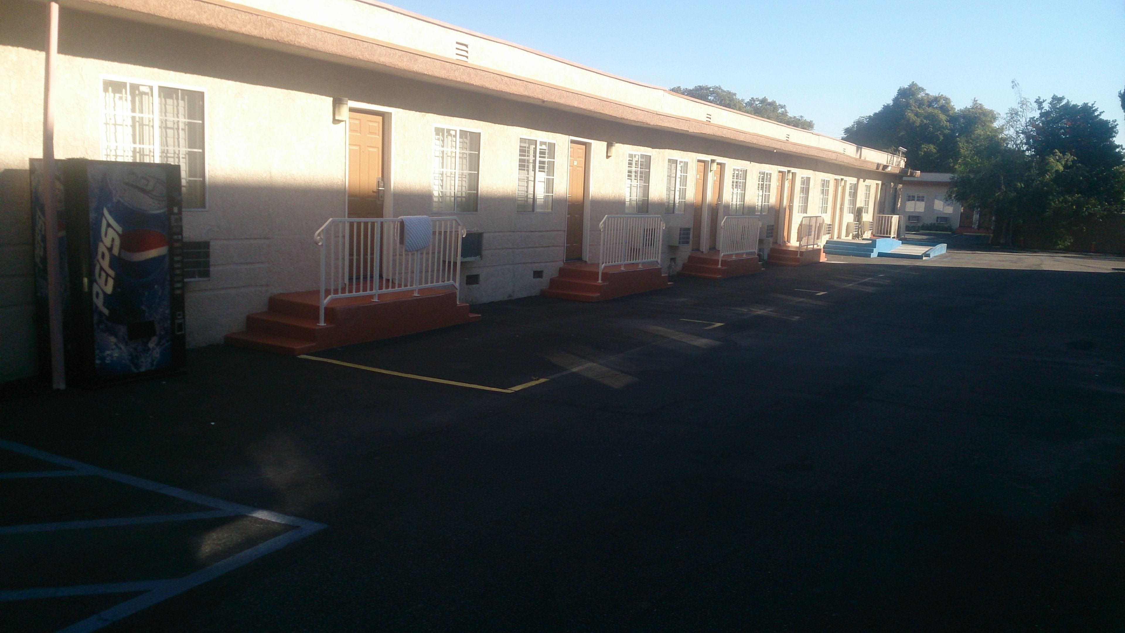 Un motel con varias habitaciones, cada una con un pequeño porche y una puerta.