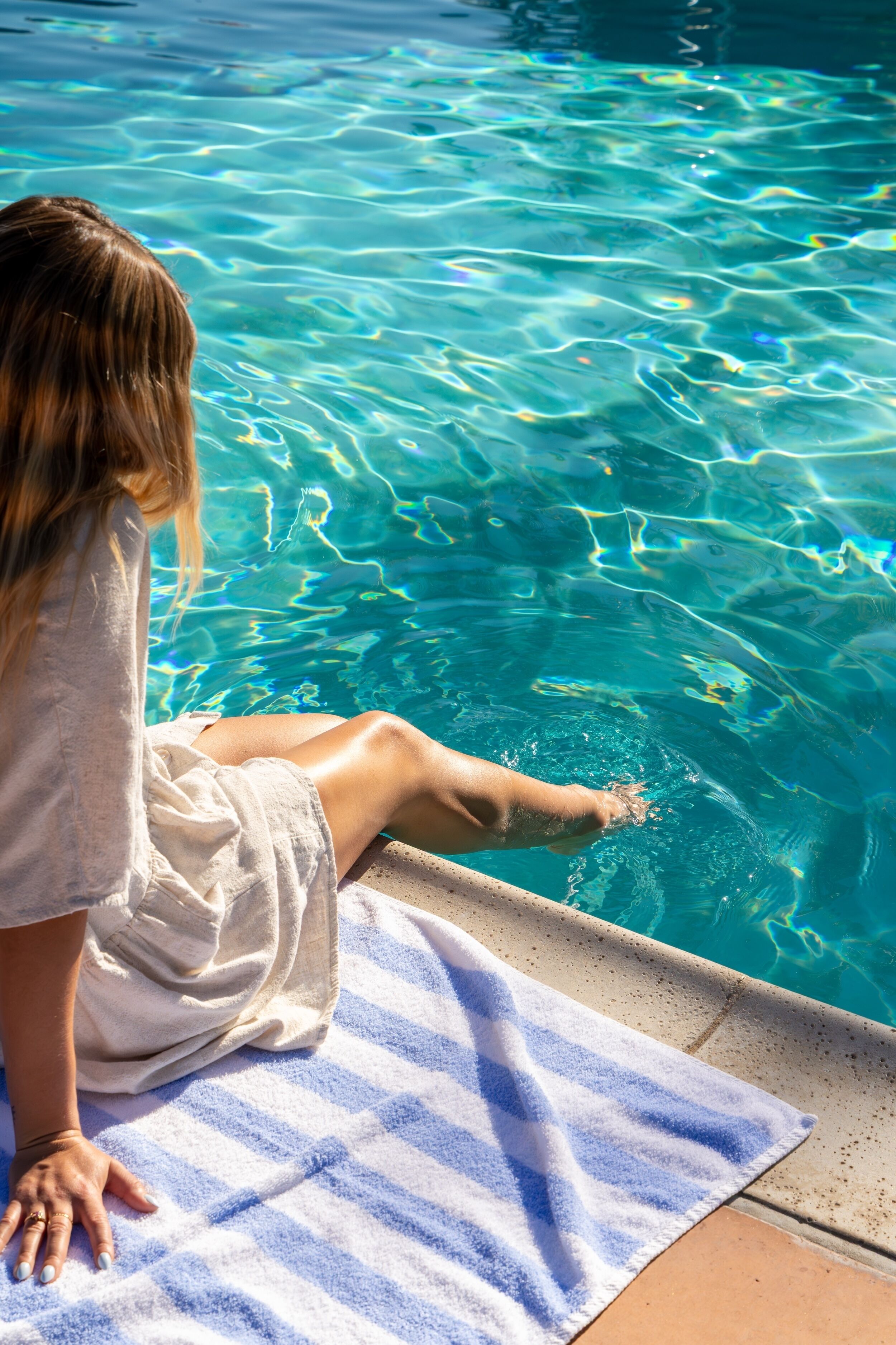 Una piscina al aire libre, camas de piscina con cargo, sombrillas