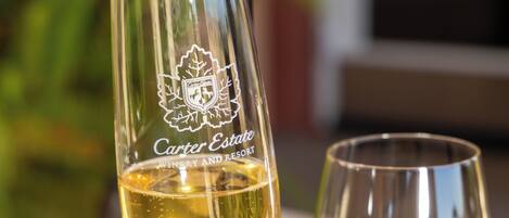 Three wine glasses with Carter Estate branding, one with white wine and another with red wine, on a table.